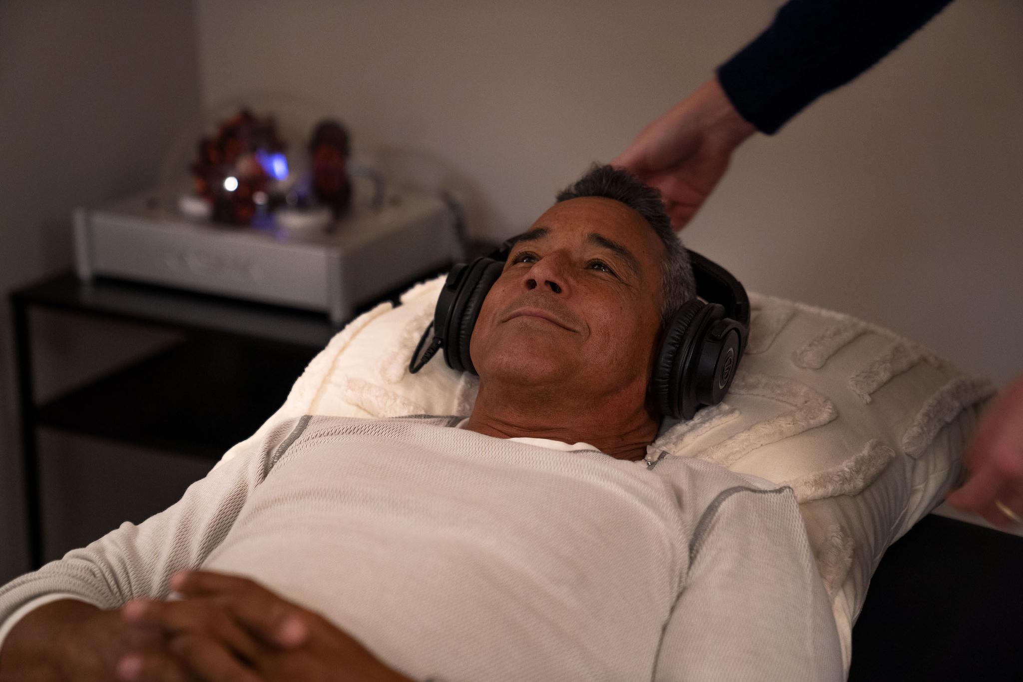 Man undergoing sound therapy with headphones at Quantum Clinic for stress relief and relaxation
